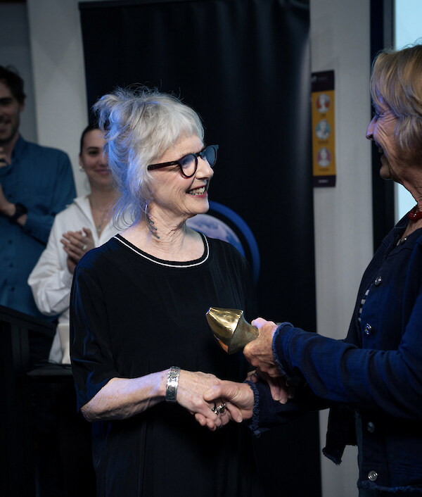 The 2025 NZMSS Award recipient Di Tracey (Earth Science New Zealand (ESNZ), previously National Institute of Water & Atmospheric Research (NIWA)), receiving her award from Council Member Kathy Walls (Ministry of Primary Industries). Photo credit Luke McPake, ESNZ.